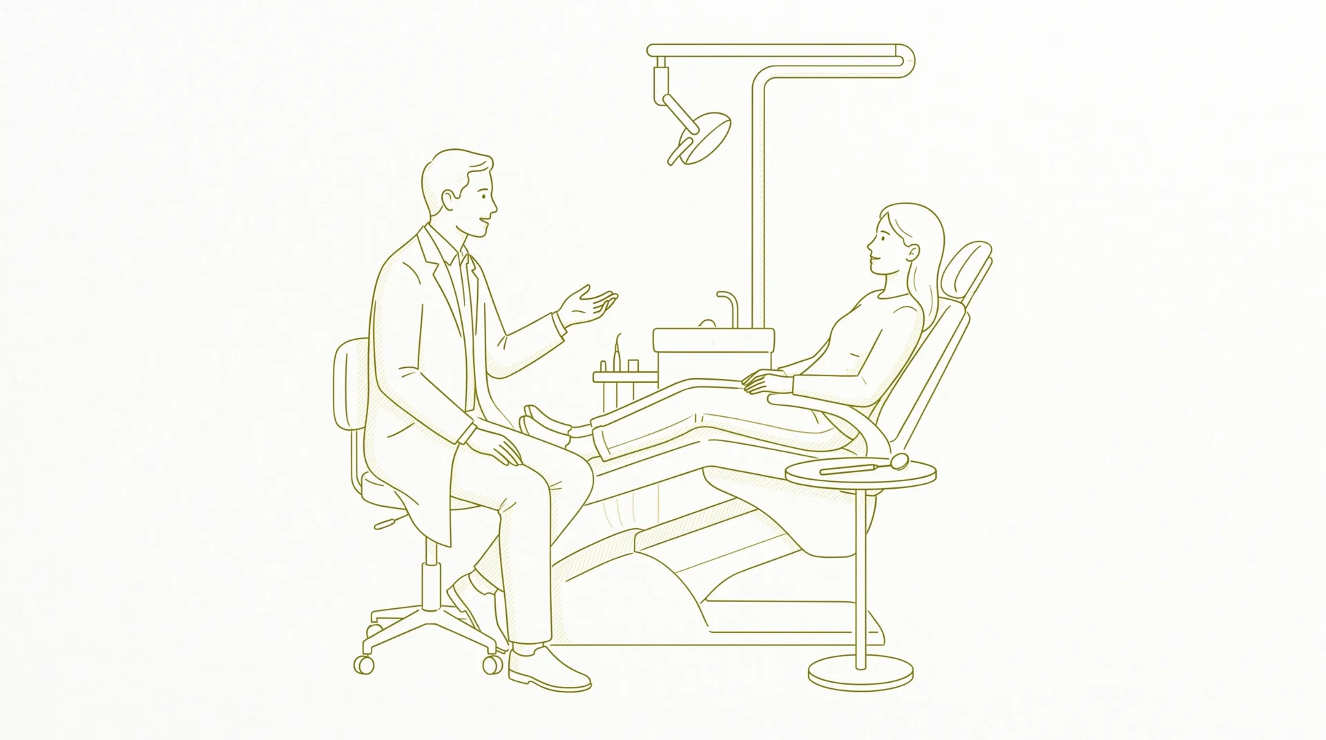 A dentist speaks calmly with an adult patient seated in a treatment chair, with a dental mirror nearby during a gentle dental appointment.